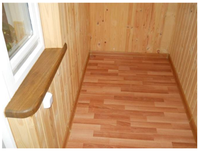 Отделанная ламинатом лоджия выглядит достаточно презентабельно.